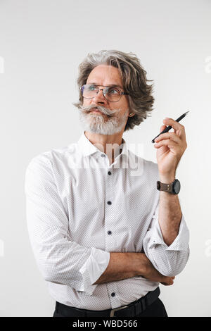 Porträt einer stattlichen nachdenklich reife Geschäftsmann in formale Abnutzung, die auf weißem Hintergrund gekleidet, mit einem Stift, weg schauen Stockfoto