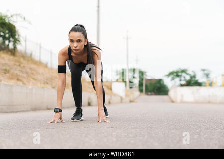 Attraktive selbstbewussten jungen Fitness Mädchen im Freien, immer bereit zu starten Stockfoto