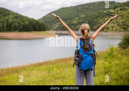 Frau Wanderer mit erhobenen Armen genießt in schönen Blick in die Natur. Stockfoto