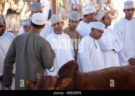 Männer tragen traditionelle Kleidung und bestickte Caps am Viehmarkt, Nizwa, Sultanat Oman Stockfoto