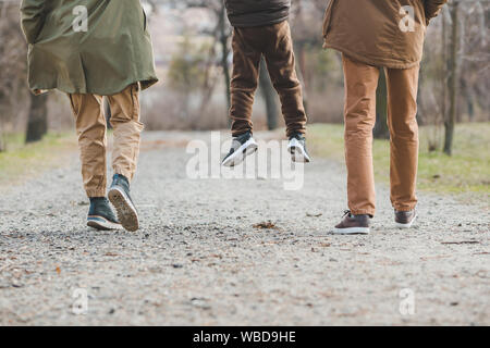 Junge schöne Familie gehen Hand in Hand durch die City Park Stockfoto