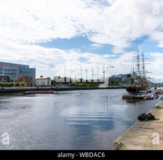 . Eine Szene auf dem Fluss Liffey mit der jeanie Johnston Replik Hungersnot Schiff auf der rechten Seite, eine rote Tour Boot auf einer Stadtrundfahrt. Stockfoto