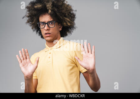 Foto von schockiert kaukasischen Mann mit Afro Frisur zeigt stop Geste mit Palmen über grauer Hintergrund Stockfoto