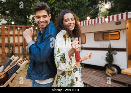 Portrait von lustig Paar Mann und Frau lächelnd während sie tanzen zusammen in der Nähe von Haus auf Rädern im Freien Stockfoto