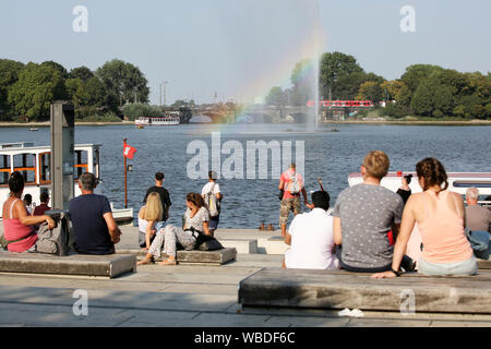 Hamburg, Deutschland. 26 Aug, 2019. Am Nachmittag wurden zahlreiche Leute sitzen bei Temperaturen über 30 Grad Celsius auf der Binnenalster und an der Alster Brunnen, wo Sonnenlicht bricht und die Farben des Regenbogens zeigen. Credit: Bodo Marks/dpa/Alamy leben Nachrichten Stockfoto