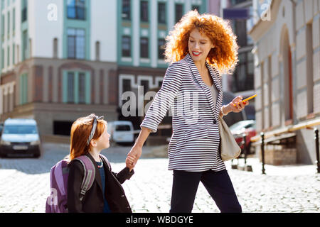 Positiv erfreut, rothaarige Frau an ihr Kind suchen Stockfoto