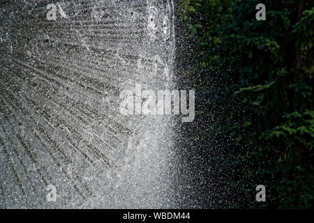 Brunnen in die Sonne und Hintergrundbeleuchtung. Die Fontänen sprudeln sprudelndes Wasser aus der Leitung im Park. Stockfoto