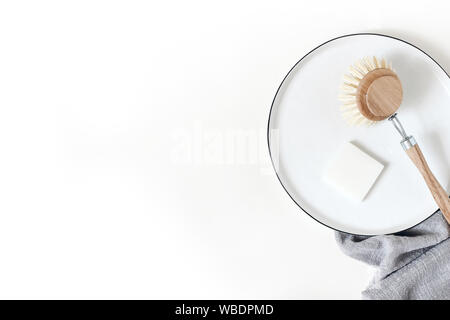 Natürliche Holz Teller Bürste, Seife und Handtücher Geschirrtuch auf weißem Hintergrund. Kunststoff Reinigung Werkzeug, null Abfall Konzept. Flat l Stockfoto