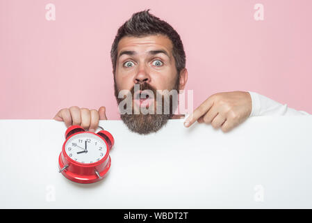 Mann mit dem langen Bart halten Wecker. Stockfoto