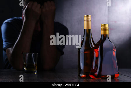 Flaschen mit alkoholischen Getränken und die Abbildung von einem betrunkenen Mann Stockfoto