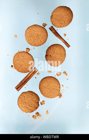 Ingwer cookies mit trockenen Apple und orangen Scheiben und Zimtstange Fliegen auf blauem Hintergrund. Essen Levitation. Weihnachten Konzept Stockfoto