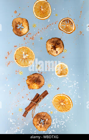 Ingwer cookies mit trockenen Apple und orangen Scheiben und Zimtstange Fliegen auf blauem Hintergrund. Essen Levitation. Weihnachten Konzept Stockfoto