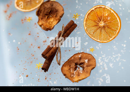 Ingwer cookies mit trockenen Apple und orangen Scheiben und Zimtstange Fliegen auf blauem Hintergrund. Essen Levitation. Weihnachten Konzept Stockfoto