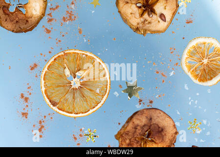 Ingwer cookies mit trockenen Apple und orangen Scheiben und Zimtstange Fliegen auf blauem Hintergrund. Essen Levitation. Weihnachten Konzept Stockfoto