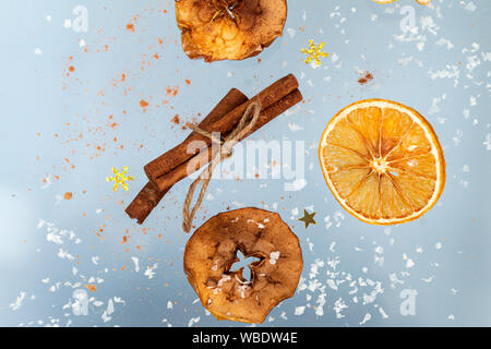 Ingwer cookies mit trockenen Apple und orangen Scheiben und Zimtstange Fliegen auf blauem Hintergrund. Essen Levitation. Weihnachten Konzept Stockfoto