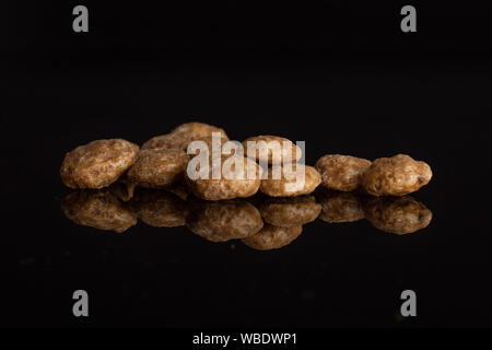 Menge ganze Schokolade Kugel Frühstückszerealien heap auf schwarzem Glas isoliert Stockfoto