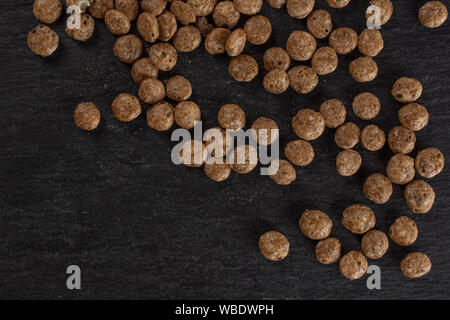 Menge ganze Schokolade Kugel Frühstückszerealien flatlay am grauen Stein Stockfoto