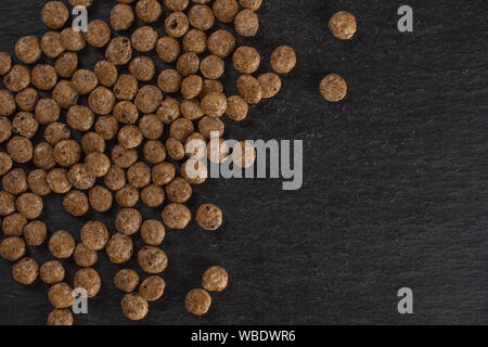 Menge ganze Schokolade Kugel Frühstückszerealien flatlay am grauen Stein Stockfoto