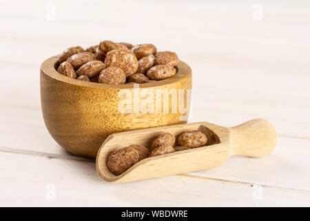 Menge ganze Schokolade Kugel Frühstückszerealien in Houten mit Holz- Schaufel auf weißem Holz Stockfoto