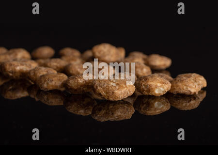 Menge ganze Schokolade Kugel Frühstückszerealien auf schwarzem Glas isoliert Stockfoto