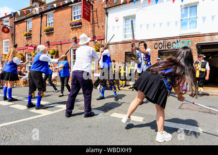 Sandwich Folk und Ale-Festival Veranstaltung in Großbritannien. Traditionelle Volkstänzer, Royal Liberty Morris Seite holding Holz- Mitarbeiter beim Tanzen auf der Straße. Stockfoto