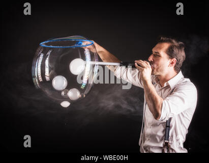 Künstler halten große Seifenblase in seinen Händen. Bubble show studio Konzept. Stockfoto