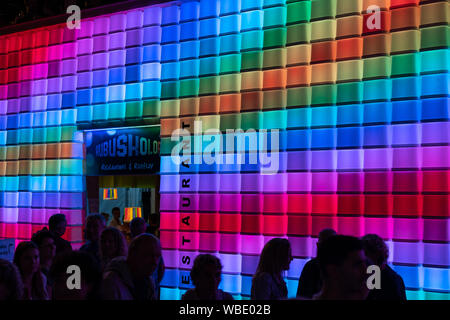 Stadtfest Brugg 24. august 2019. Nacht der Fotografie. Blau Rot Grün erleuchteten Wand von einem Restaurant namens Kubus Kolor mit Menschen Stockfoto