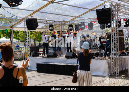 Stadtfest Brugg 25 August 2019. street photography. Mitglied in die Band auf der Bühne mit zwei Kindern, die einen Song mit der Band durchgeführt hat. Stockfoto