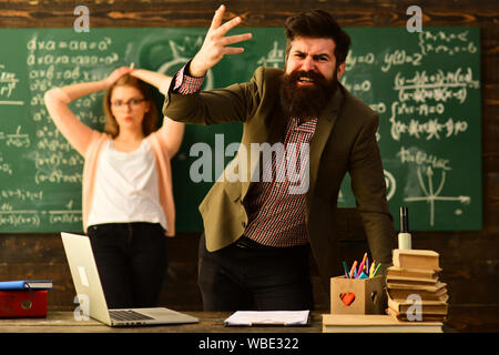 Tutor neben Schreibtisch während Privatunterricht zu Hause sitzen, einige Schülerinnen und Schüler am besten durch Zuhören lernen, Lehrer schafft Gefühl von Gemeinschaft und Zugehörigkeit in Stockfoto