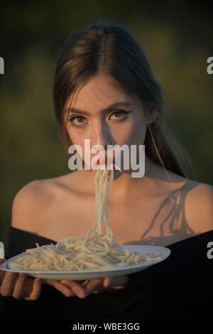 Hunger, Appetit, Rezept. Italienische Nudeln oder Spaghetti zum Abendessen kochen. Diät und gesunde Lebensmittel aus biologischem Anbau, Italien. Koch Frau mit roten Lippen essen Pasta Stockfoto