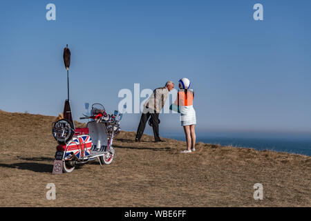 Ein mod Paar Blick über die Klippe bei Beachy Head durch Ihre 1960er Lambretta scooter mit Union Jack/Jack Aufkleber Stockfoto