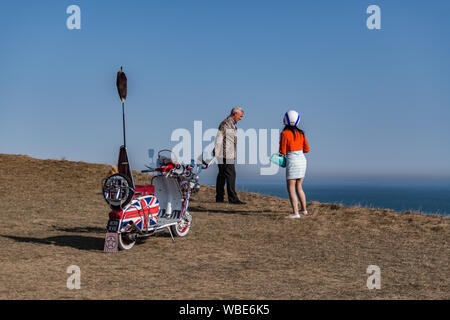 Ein mod Paar Blick über die Klippe bei Beachy Head durch Ihre 1960er Lambretta scooter mit Union Jack/Jack Aufkleber Stockfoto