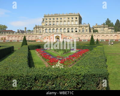 Die palastartigen Villa an Cliveden in 1666 gebaut, mit dem bunten formale Bepflanzung auf dem Parterre in Rot & Gelb für Sommer 2019 Stockfoto