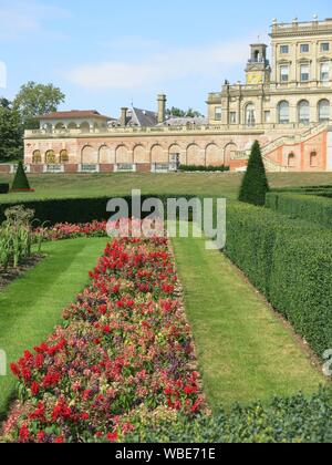 Die palastartigen Villa an Cliveden in 1666 gebaut, mit dem bunten formale Bepflanzung auf dem Parterre in Rot & Gelb für Sommer 2019 Stockfoto