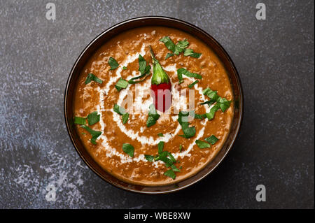 Dal Makhani auf dunklem Hintergrund. Dal Makhani - Traditionelle indische Küche Püree Gericht mit urad Bohnen, rote Bohnen, Butter, Gewürze und Sahne. Stockfoto