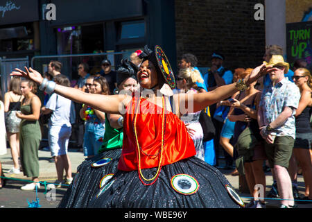 26. August 2019 - Frau in einem Kostüm zu Fuß in der Notting Hill Carnival Parade an einem heißen Feiertag Montag, London, UK Stockfoto