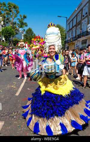 26. August 2019 - Die Menschen in historischen Kostümen und Perücken Pulver in die Parade gekleidet, Notting Hill Carnival an einem heißen Feiertag Montag, London, UK Stockfoto