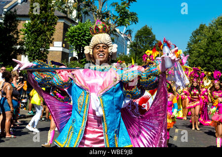 26. August 2019 - Mann, gekleidet in einen Zeitraum Kostüm mit Pulver Perücke, Krone und Flagge in Notting Hill Karneval an einem heißen Feiertag Montag, London, UK Stockfoto