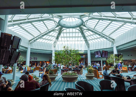 Orlando, FL/USA -8/22/19: Menschen in einem Atrium Bereich des Flughafens warten auf Ihre Flüge Orlando am internationalen Flughafen. Stockfoto