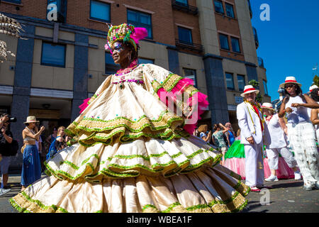 26. August 2019 - Tänzerin tragen ein großes Kleid und Kopfbedeckung in Notting Hill Karneval an einem heißen Feiertag Montag, London, UK Stockfoto