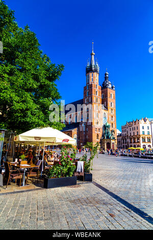 Blick auf die Cafés und Restaurants auf dem Marktplatz (Rynek Glowny) mit Sy Marys Basilika im Hintergrund, Krakau, Polen Stockfoto