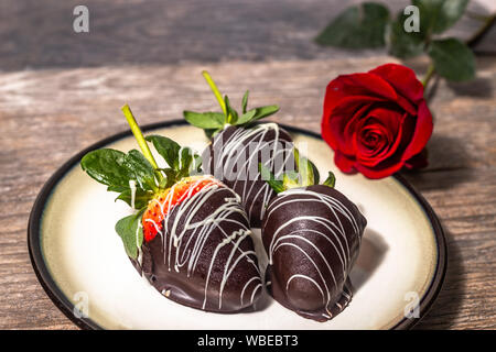 Romantische Rosen, mit Schokolade überzogene Erdbeeren Stockfoto