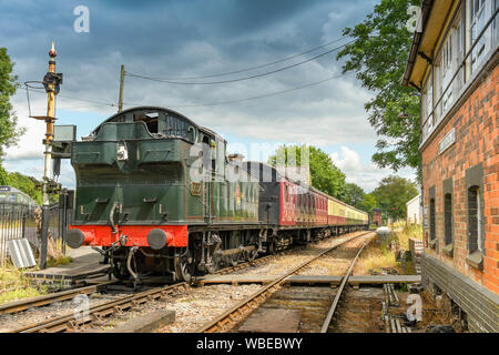 CRANMORE, ENGLAND - Juli 2019: Dampfmaschine und Zug von Wagen warten Cranmore Station auf der East Somerset Railway zu fahren. Stockfoto