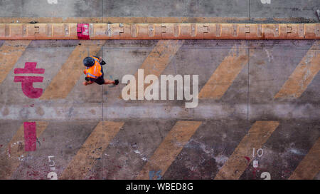 Liegeplatz Mann mit orange Weste bei der Arbeit auf der Station. Stockfoto