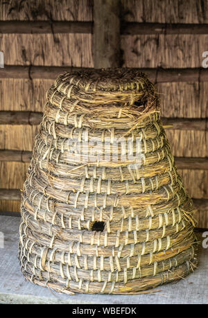 Bokrijk, Belgien - 27 Juni, 2019: Nahaufnahme von klassischen großen gelblich-braun Stroh Bienenstock unter der Markise. Stockfoto