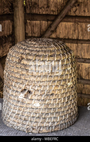 Bokrijk, Belgien - 27 Juni, 2019: Nahaufnahme von klassischen großen gelblich-braun Stroh Bienenstock unter der Markise. Stockfoto