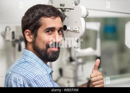 Patienten in der modernen Augenheilkunde Klinik Kontrolle der Eye Vision, Daumen nach oben zeigt. Stockfoto