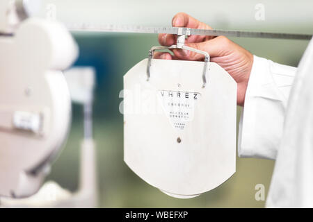 Patient ist das Lesen der optometrist Chart in der modernen Augenheilkunde Klinik. Stockfoto