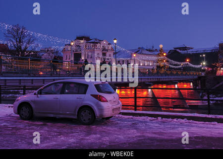 Uschhorod, Ukraine - 06 Jan, 2019: Winter Dawn in der Stadt. Wunderbare städtische Landschaft mit City Light auf der Brücke und Weihnachtsbaum in der Ferne. verschmutzt Stockfoto