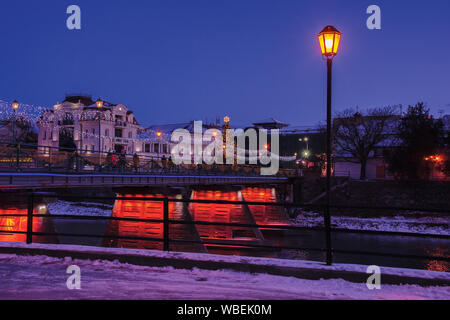 Uschhorod, Ukraine - 06 Jan, 2019: Winter Dawn in der Stadt. Wunderbare städtische Landschaft mit City Light auf der Brücke und Weihnachtsbaum in der Ferne. lante Stockfoto